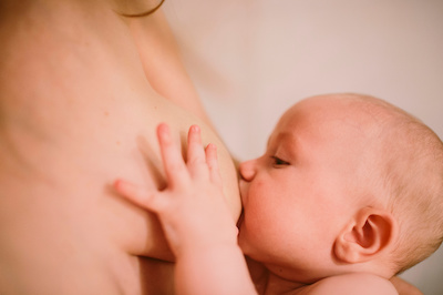 Baby feeding on the breast of his mother who breastfeeds.