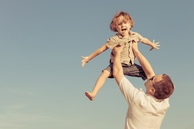 Dad and son playing near a house at the day time