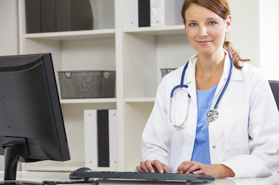 Woman female medical doctor using computer in her hospital office