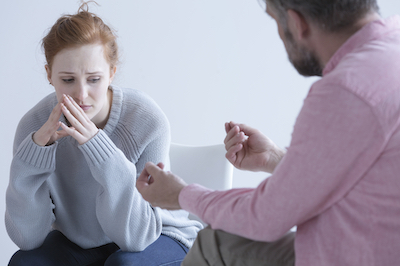Young woman having post abortion stress, talking with psychologist