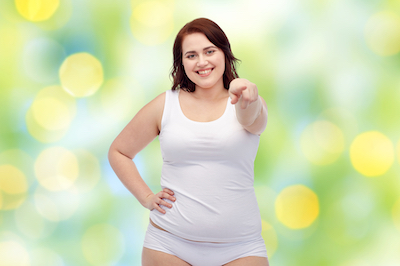 gesture, weight loss and people concept - smiling young plus size woman in underwear showing over green lights background