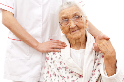 young doctor's hand on an old woman patient's shoulder